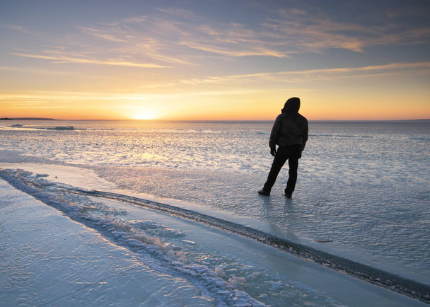 Winter landscape and man looking on sunset. Ice blocks. Composition of nature. - Фото, изображение