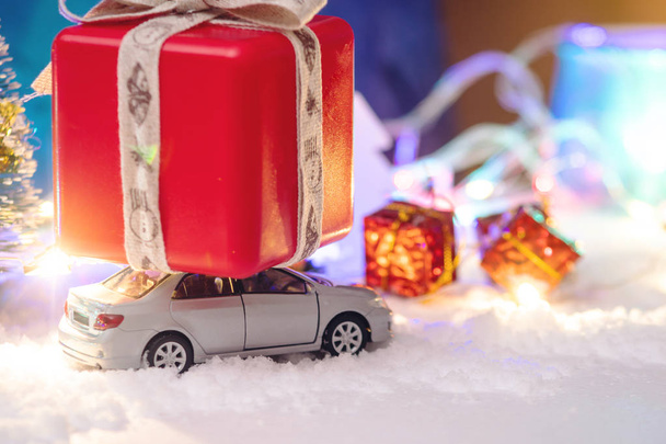 Αυτοκίνητο παιχνίδι φέρνει δώρα για τα Χριστούγεννα και της Πρωτοχρονιάς σε μπλε φόντο. Η έννοια των διακοπών που ψωνίζουν και εκπτώσεις - Φωτογραφία, εικόνα