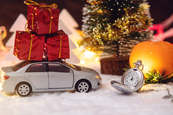 Orologio da tasca sulla neve con auto e regali alla vigilia delle vacanze. Concetto in attesa della magia del Natale e del nuovo anno
 - Foto, immagini