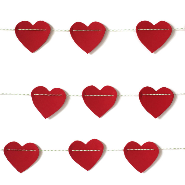 Κόκκινο χαρτί καρδιά που κρέμεται από το άπλωμα. σε λευκό φόντο - Φωτογραφία, εικόνα