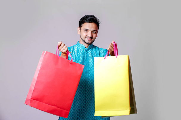 Indian man w etniczne zużycie z torby na zakupy, na białym tle nad białym tle - Zdjęcie, obraz