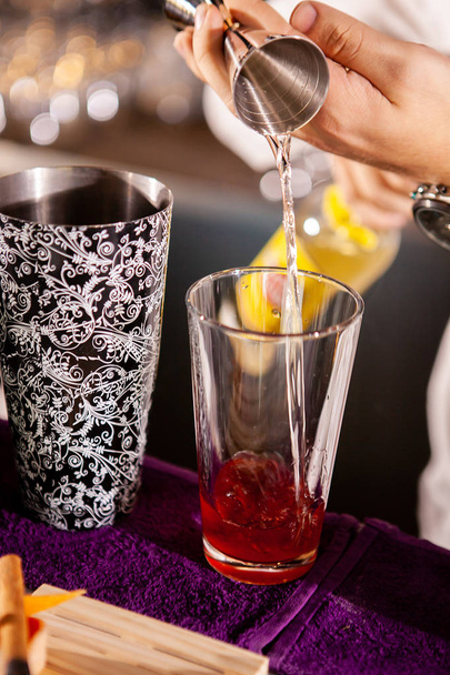 Closeup of bartender hands pouring alcoholic drink - Foto, imagen