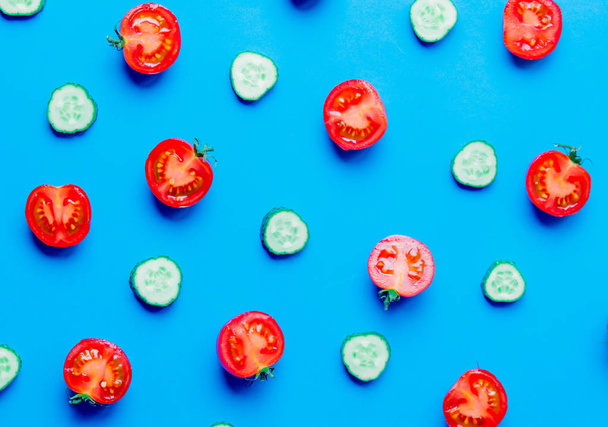 Vista acima em tomates e pepinos em fundo azul
 - Foto, Imagem