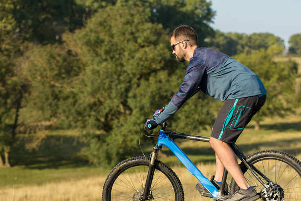 Cyklista v šortkách a dres na moderní karbonové kolo hardtail s vzduchem Odpružená vidlice - Fotografie, Obrázek