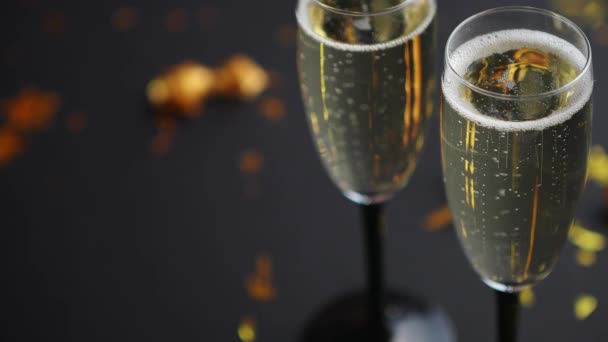 Deux verres pleins de champagne mousseux avec décoration dorée - Séquence, vidéo