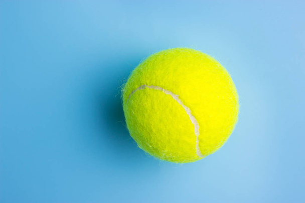 Big tennis ball on blue background - Trendy minimal design top view - Photo, image