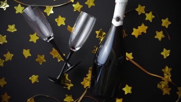 Vasos y botella de champán con serpentinas doradas y confeti - Metraje, vídeo