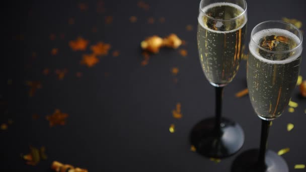 Twee glazen sprankelende champagnewijn met gouden decoratie - Video