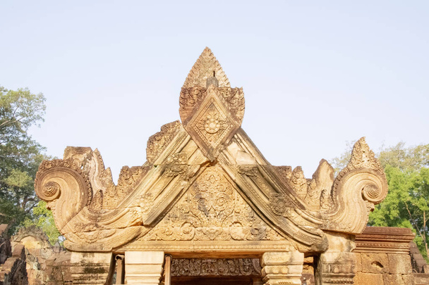 Камбоджа, Бантеай-Сей - март 2016 - Декоративные перемычки в реконструированных руинах орнаментально резного 10-го века, красного песчаника, храма, посвященного индуистскому богу Шиве, купающиеся в раннем утреннем свете
 - Фото, изображение