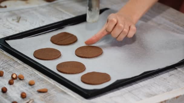 Rauwe chocolade koekjes op een bakplaat met perkamentpapier, klaar voor bak zetten. - Video