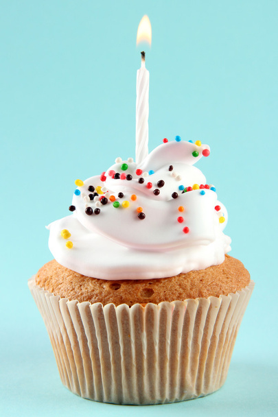 tasty birthday cupcake with candle, on blue background - Фото, зображення
