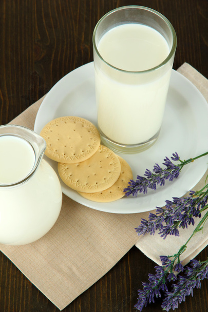 Glass of milk, a jug and cookies on a wooden background - Foto, Bild