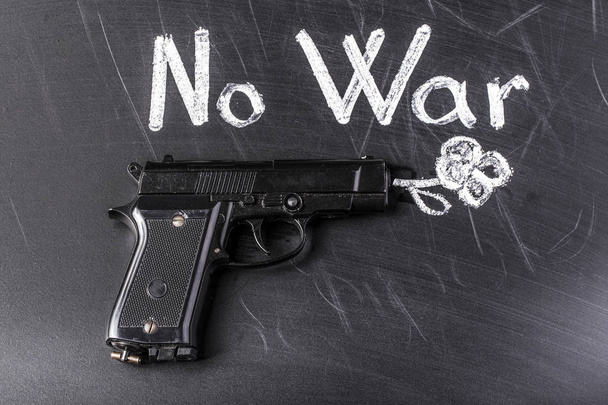 a fegyver, hogy lő egy virágot, közel a felirat, ott nincs háború - Fotó, kép