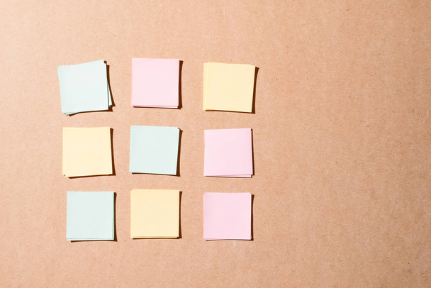 blank colorful sticky notes on wooden wall - Foto, afbeelding