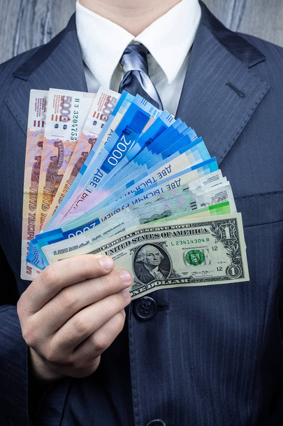 A man holds rubles and dollars in his hand, a businessman holds money in his hand - Foto, immagini