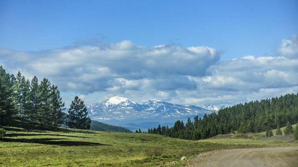 Beautiful views and landscape of Altai nature. Perspective of the road and highway in Altai, against the backdrop of majestic mountains covered with forest and sky with clouds. - Photo, Image