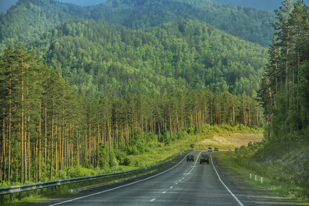 schöne Ausblicke und Landschaft der Altai-Natur. die Aussicht auf Straßen und Autobahnen im Altai, vor dem Hintergrund majestätischer Berge, die von Wäldern bedeckt sind. - Foto, Bild