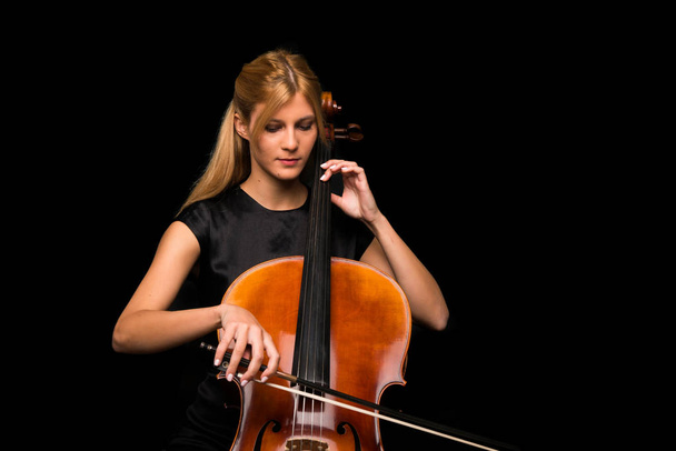 Jovem tocando violoncelo em fundo preto isolado
 - Foto, Imagem
