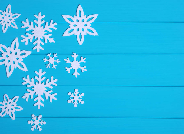 Schneeflocken und Sterne auf blauem Holzgrund - Foto, Bild