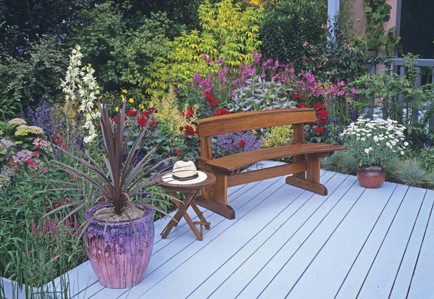 Seat, decking with colourful flower border ready for retirement - Photo, Image