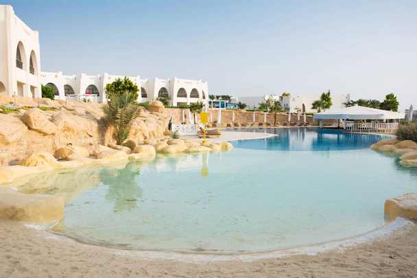 Basen z piasku wejście w Egipcie. Puste leżaki przy basenie - Zdjęcie, obraz