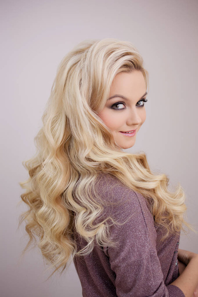 Charming smiling blonde with luxurious blonde curls. Hair beauty - 写真・画像