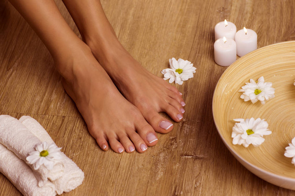 The picture of ideal done manicure and pedicure. Female hands and legs in the spa spot. - 写真・画像