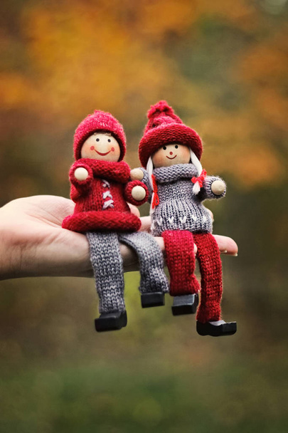 Komedia romantyczna para drewnianych lalek wiązane zużycie siedzą na dłoni. - Zdjęcie, obraz