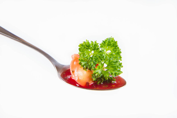 Traditional polish Christmas Eve dish: red borscht with uszko (a mushroom filled kind of dumpling) on a spoon decorated with parsley - Photo, Image