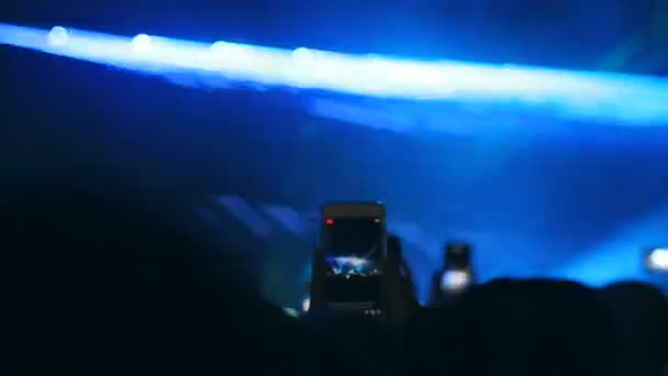 Zuschauer filmten den Künstler während eines Auftritts auf der Bühne am Telefon. viele Leute mit eingeschaltetem Smartphone, um während des Live-Konzerts aufzunehmen oder Fotos zu machen. - Filmmaterial, Video
