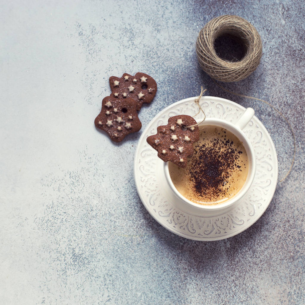 Cup of coffee, chocolate cookies and spool of thread on grey stone background. Flat lay. Christmas concept - Foto, Imagem