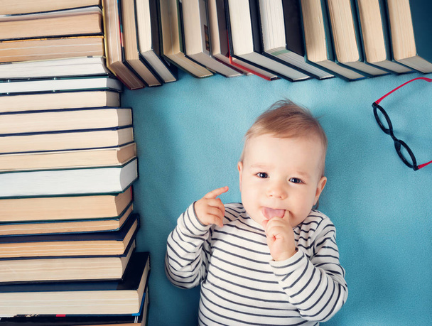 One year old baby among books with spectackles.Happy little child reading - Fotó, kép