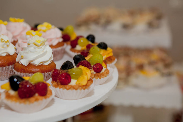 cupcakes with raspberries, grapes and peach on a wedding table - Fotografie, Obrázek