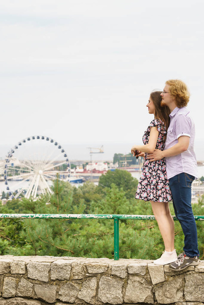 Man and woman having romantic date looking at city panorama view and ferris wheel outdoor. Couple romance moments concept. - Foto, imagen