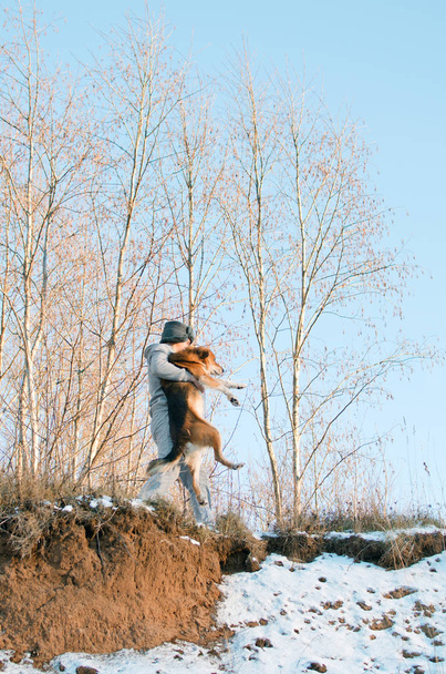 mladý muž nese psa až neprůchodné zimní les - Fotografie, Obrázek