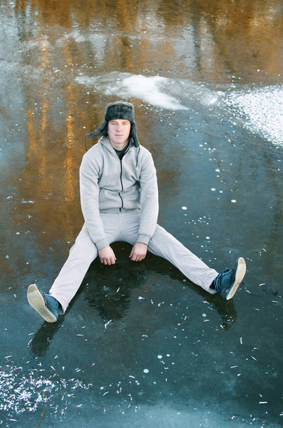 guy in the gray tracksuit sitting on the ice - Photo, Image
