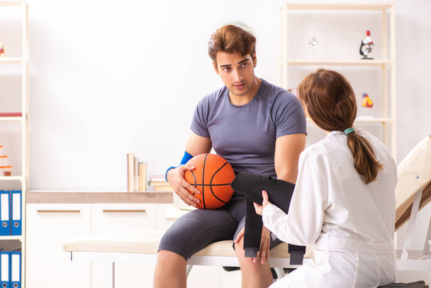 Handsome basketball player visiting female doctor traumatologist - Photo, Image