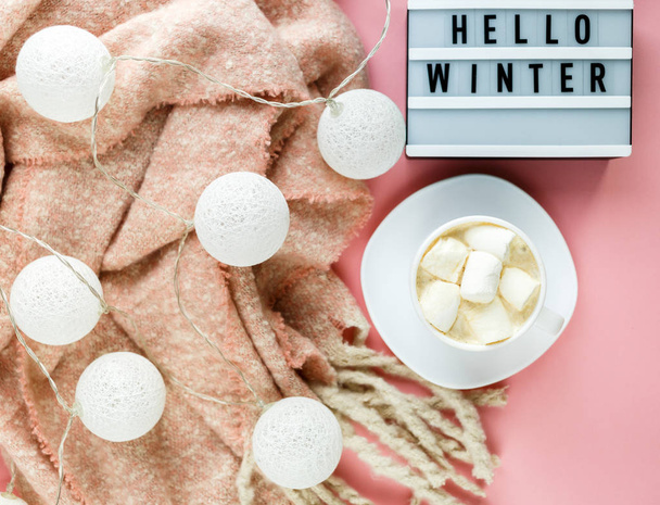 warmer, gemütlicher Winterschal, Leuchtkasten auf Pastell und Tasse Kaffee mit marshmallow rosa Hintergrund. Weihnachten, Neujahr Konzept flach gelegt. Hallo Wintertitel - Foto, Bild
