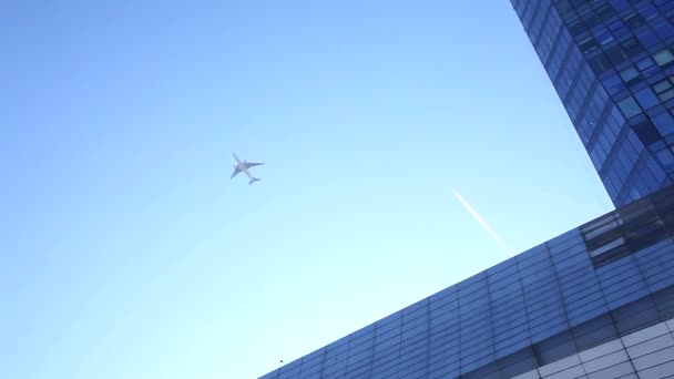 Avión volando sobre edificios de oficinas de vidrio y diseño futurista
 - Metraje, vídeo