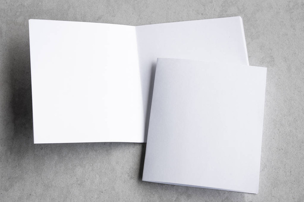 Blank portrait mock-up paper. brochure magazine isolated on gray, changeable background / white paper isolated on gray cement backdrop. - Foto, afbeelding