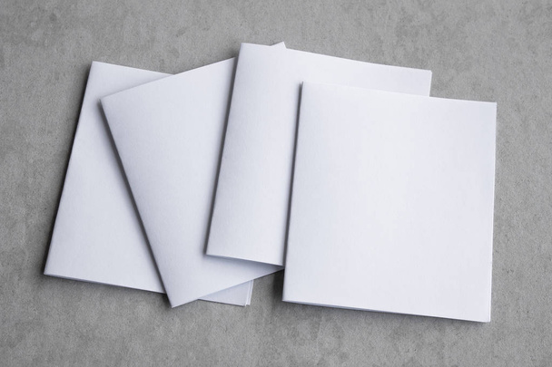 Blank portrait mock-up paper. brochure magazine isolated on gray, changeable background / white paper isolated on gray cement backdrop. - Fotografie, Obrázek