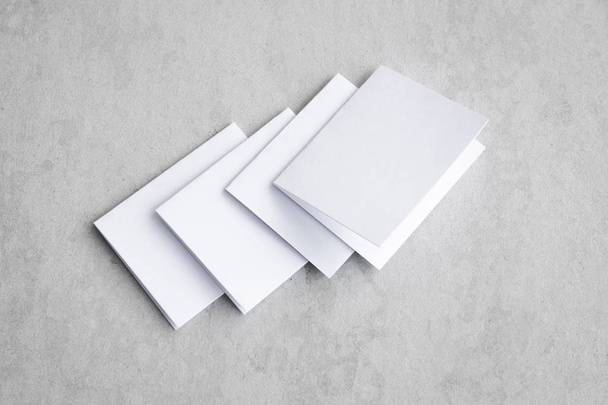 Blank portrait mock-up paper. brochure magazine isolated on gray, changeable background / white paper isolated on gray cement backdrop. - Фото, зображення