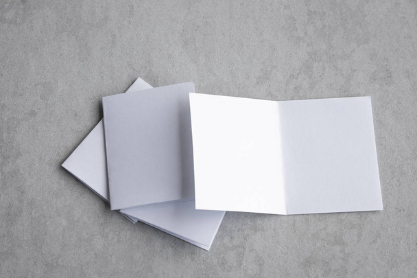 Blank portrait mock-up paper. brochure magazine isolated on gray, changeable background / white paper isolated on gray cement backdrop. - Foto, Imagen
