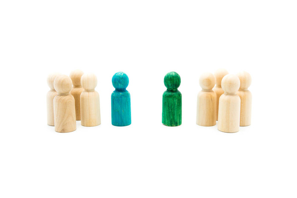 Деревянные фигуры в очереди в качестве бизнес-команды, с синими и зелеными фигурами, выделяющимися из толпы, изолированными на белом фоне. Концептуальный образ лидерства и отличаемости
 - Фото, изображение