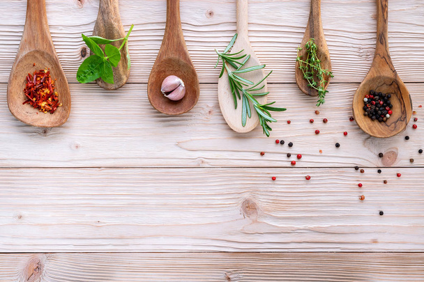 Various of spices and herbs in wooden spoons. Flat lay spices ingredients chili ,peppercorn, rosemarry, thyme,star anise ,sage leaves and sweet basil on shabby wooden. - Photo, Image