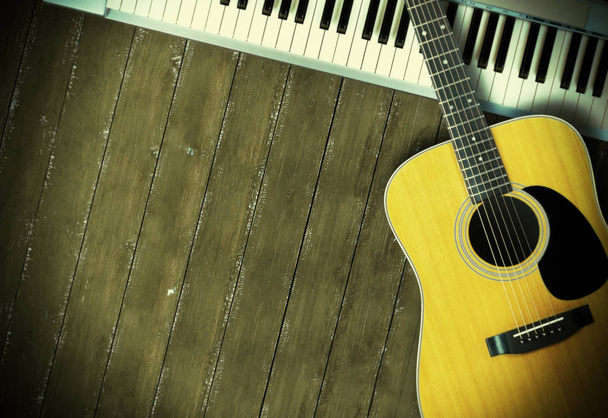 Музичний інструмент - Sloseup MIDI piano 61 клавіатура та акустична гітара на дерев'яному фоні
 - Фото, зображення