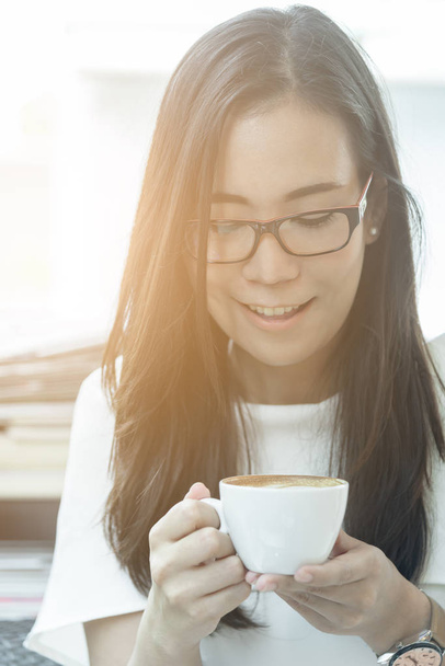 Belle asiatique attrayant femme a tenant et boire un café au café le matin avec le temps heureux et relaxant. - Photo, image