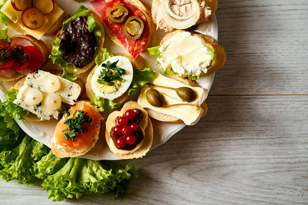 пластины с красочными и здоровыми бутербродами или тапас на деревянном столе
 - Фото, изображение
