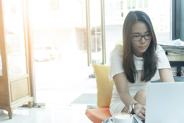 Krásná asijské atraktivní žena má práci a psaní na notebooku pro podnikání marketing v kavárně v dopoledních hodinách s šťastný a relaxační čas. - Fotografie, Obrázek