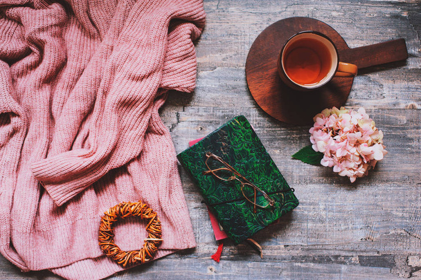 autumn or summer garden table top view with cozy sweater, coffee, glasses, sketch book, dried hydrangea flowers on wooden background - Φωτογραφία, εικόνα